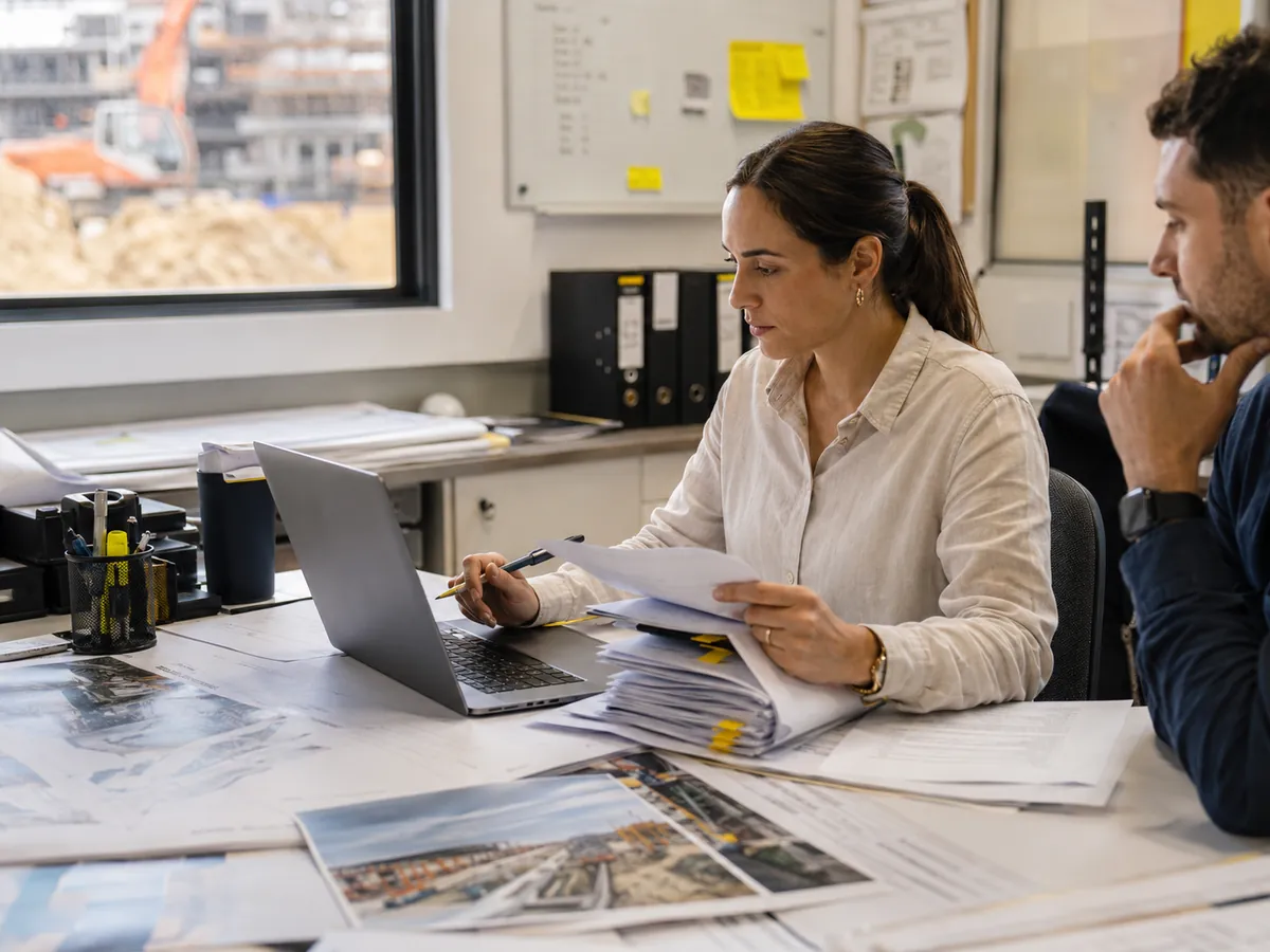 Contracts administrator reviewing project correspondence and variation documents in a site office